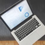 Laptop z wykresami danych i analizą wyników SEO