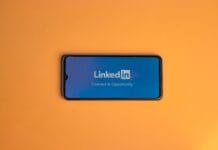 Czy reklamy mobilne mogą zastąpić tradycyjne billboardy? Analiza lokalnej kampanii Ekran logowania LinkedIn na smartfonie na pomarańczowym tle