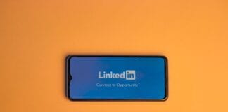 Ekran logowania LinkedIn na smartfonie na pomarańczowym tle