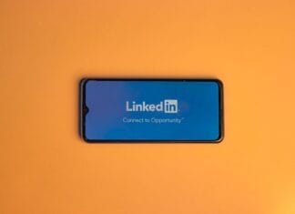 Ekran logowania LinkedIn na smartfonie na pomarańczowym tle