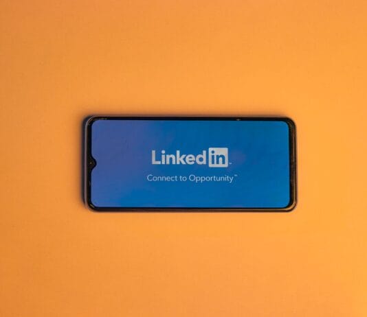 Ekran logowania LinkedIn na smartfonie na pomarańczowym tle
