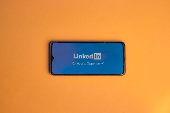 Ekran logowania LinkedIn na smartfonie na pomarańczowym tle Ekran logowania LinkedIn na smartfonie na pomarańczowym tle