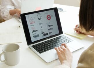 Jak pisać tytuły i meta opisy, które poprawiają CTR i szybkość zdobywania pozycji Spotkanie zespołu przy stole z laptopami i notatkami o SEO