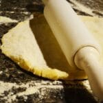 Wałkowanie ciasta na pizzę na oprószonym mąką blacie
