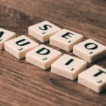 Kafelki scrabble układające się w napis SEO Audit na drewnianym tle