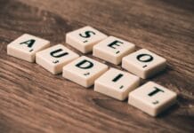 Jak zrobić audyt SEO krok po kroku i nie pominąć kluczowych błędów Kafelki scrabble układające się w napis SEO Audit na drewnianym tle