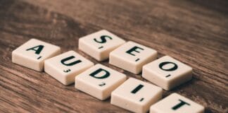 Kafelki scrabble układające się w napis SEO Audit na drewnianym tle