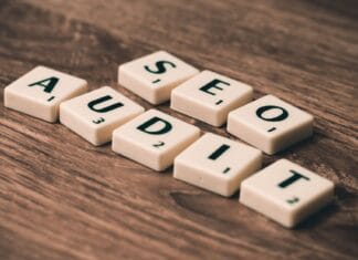 Jak zrobić audyt SEO krok po kroku i nie pominąć kluczowych błędów Kafelki scrabble układające się w napis SEO Audit na drewnianym tle