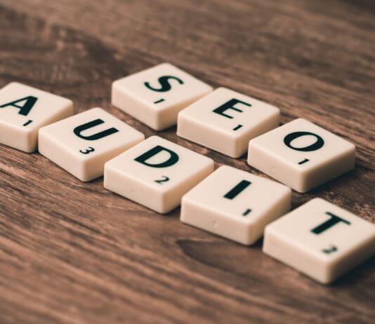 Jak zrobić audyt SEO krok po kroku i nie pominąć kluczowych błędów Kafelki scrabble układające się w napis SEO Audit na drewnianym tle