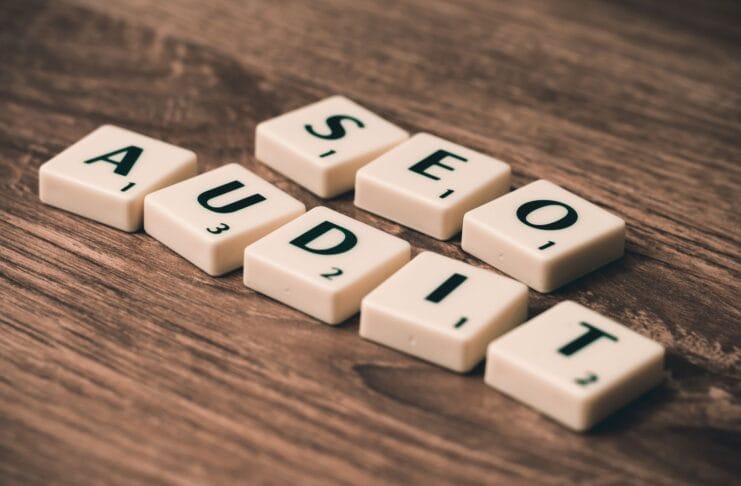 Kafelki scrabble układające się w napis SEO Audit na drewnianym tle